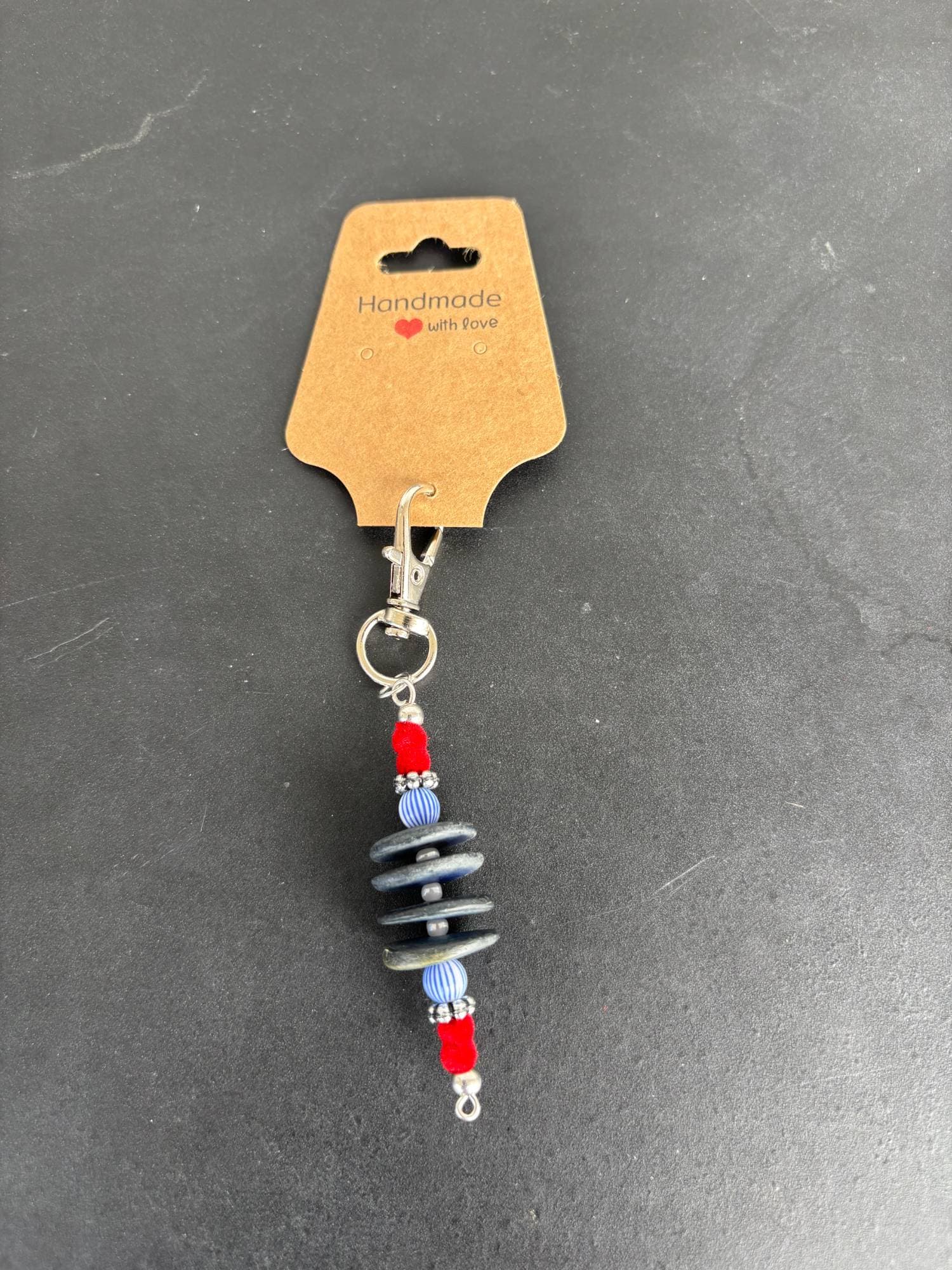 Charm of stacked slate discs with red accents