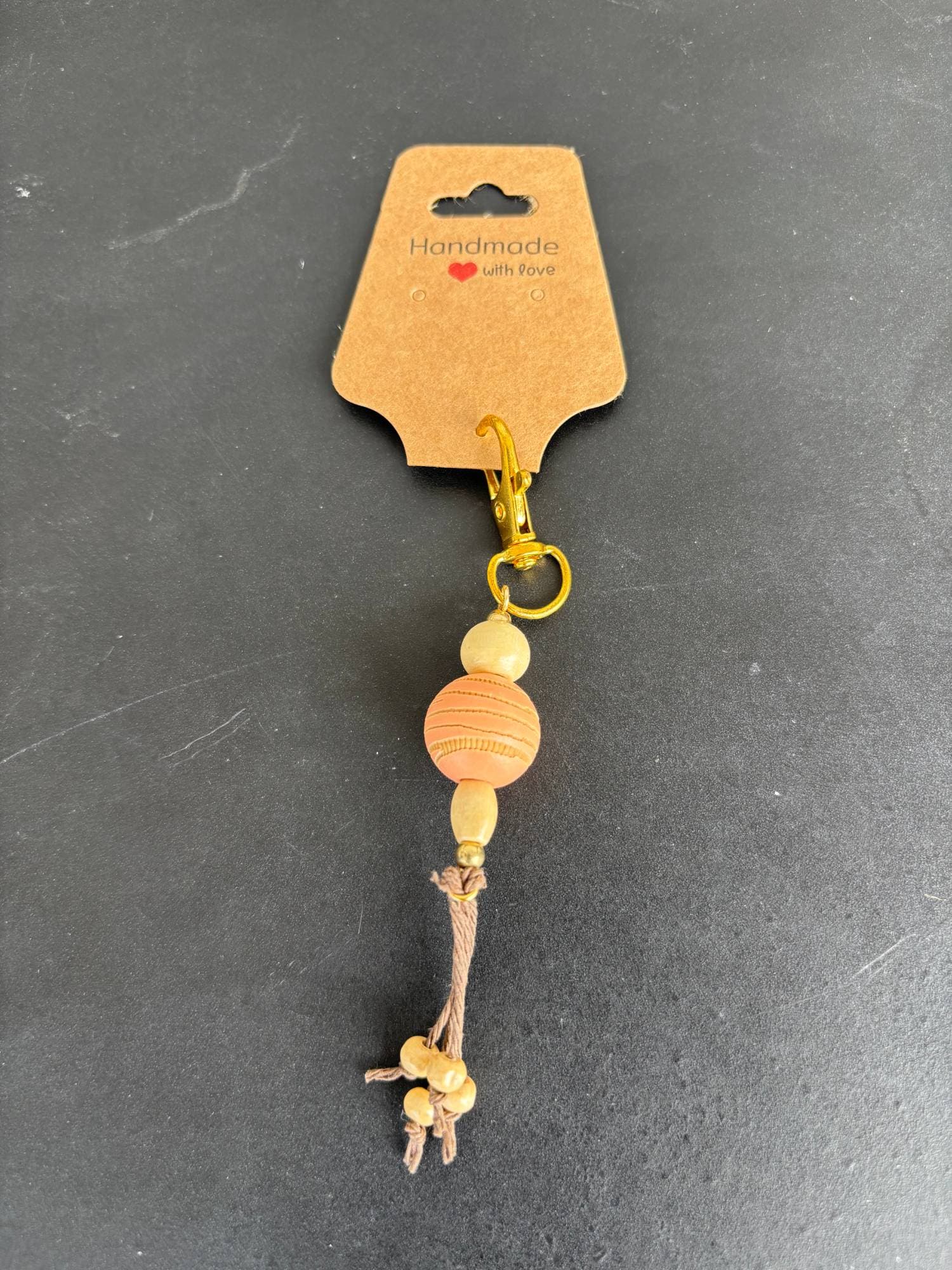Peach wood bead charm with knotted cord