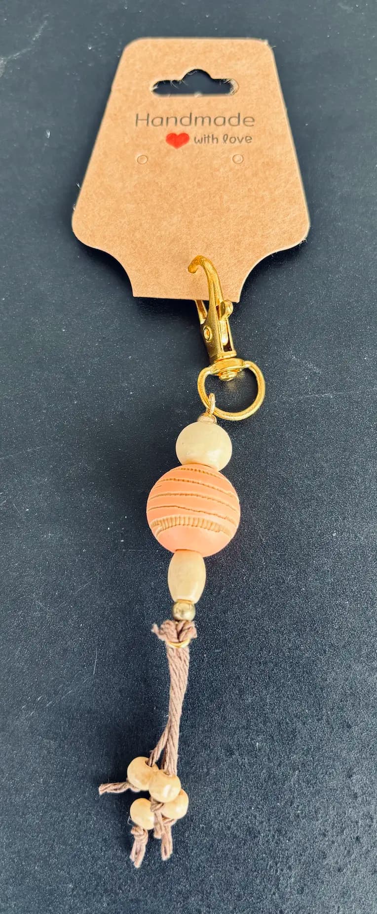 Peach wood bead charm with knotted cord