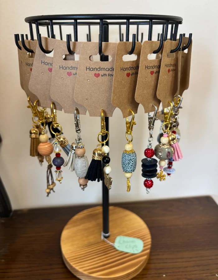 A stand of handmade charm clips on kraft cards